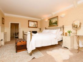 A bedroom with a bed, trunk, and paintings at Ladye Park in Liskeard