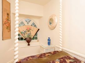 A bedroom with a decorative fan and wall art at Ladye Park in Liskeard