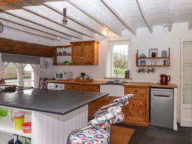 A kitchen with wooden cabinets and appliances at Old Sunday School in Welcombe near Kilkhampton