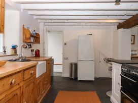 A kitchen with wooden cabinets and appliances at Old Sunday School in Welcombe near Kilkhampton