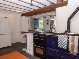 A kitchen with an Aga stove and a white fridge at Old Sunday School Welcombe near Kilkhampton
