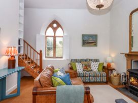 A living room with a sofa and fireplace at Old Sunday School in Welcombe near Kilkhampton