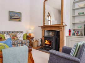 A living room with a fireplace and bookshelf at Old Sunday School Welcombe near Kilkhampton
