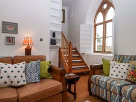 A living room with a sofa and staircase at Old Sunday School Welcombe near Kilkhampton