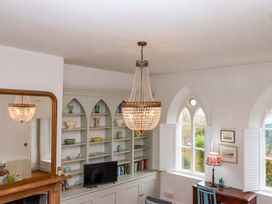 A living room with a chandelier and shelf at Old Sunday School in Welcombe near Kilkhampton