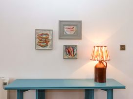 A table with a lamp and framed artwork on the wall at The Old Sunday School in Welcombe near Kilkhampton