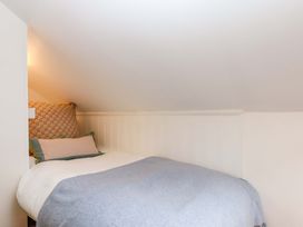 A bed with pillows and a blanket in a loft bedroom at Old Sunday School in Welcombe near Kilkhampton