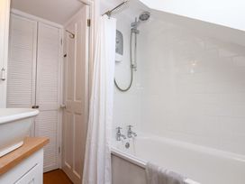 A bathroom featuring a bathtub, shower, and sink at Old Sunday School Welcombe near Kilkhampton
