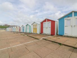 A row of colorful beach huts along a pathway at Old Sunday School Welcombe near Kilkhampton
