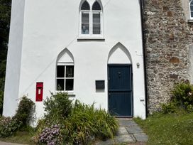 A white building with a blue door and red postbox at Old Sunday School Welcombe