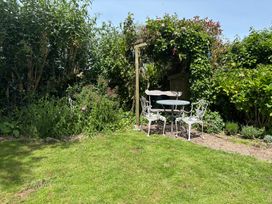A garden with a table and chairs at Old Sunday School Welcombe