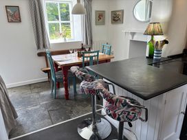 A kitchen with a dining area and bar stools at Old Sunday School in Welcombe