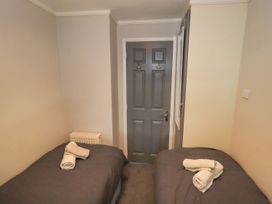 A bedroom with two beds and a door at Evermore Lodge, 48 Calgarth Park, White Cross Bay, Windermere