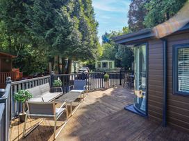 An outdoor deck with a table and chairs at Evermore Lodge, 48 Calgarth Park, White Cross Bay, Windermere