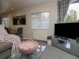 A living room with a sofa and television at Evermore Lodge 48 Calgarth Park, White Cross Bay, Windermere