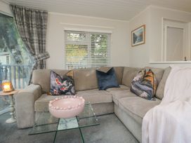 A living room with a sofa and a glass table at Evermore Lodge, 48 Calgarth Park, White Cross Bay, Windermere