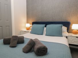 A bedroom with a bed and towels at Evermore Lodge, 48 Calgarth Park, White Cross Bay, Windermere