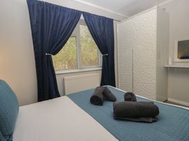 A bedroom with a bed and towels at Evermore Lodge, 48 Calgarth Park, White Cross Bay, Windermere
