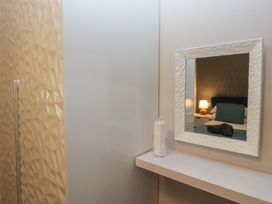 A bedroom with a mirror and bed at Evermore Lodge, 48 Calgarth Park, White Cross Bay, Windermere