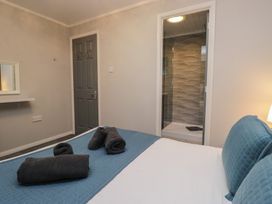 A bedroom with a bed and towels at Evermore Lodge, 48 Calgarth Park, White Cross Bay, Windermere