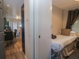 A bedroom with a bed and a door at Evermore Lodge 48 Calgarth Park, White Cross Bay, Windermere