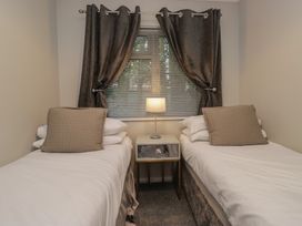 A bedroom with two beds and a lamp at Evermore Lodge, 48 Calgarth Park, White Cross Bay, Windermere