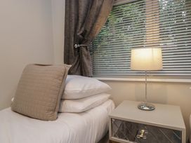 A bedroom with a bed and lamp at Evermore Lodge, 48 Calgarth Park, White Cross Bay, Windermere