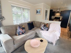A living room with a sofa and coffee table at Evermore Lodge, 48 Calgarth Park, White Cross Bay, Windermere
