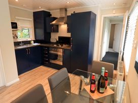 A kitchen with a stove and sink at Evermore Lodge 48 Calgarth Park, White Cross Bay, Windermere