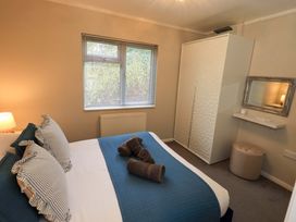 A bedroom with a bed and a wardrobe at Evermore Lodge, 48 Calgarth Park, White Cross Bay, Windermere