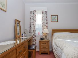 A bedroom with a bed and dressing table at Woodbury in Teignmouth