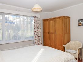 A bedroom with a bed, wardrobe, and window at Woodbury in Teignmouth