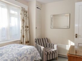 A bedroom with a bed and chair at Woodbury in Teignmouth