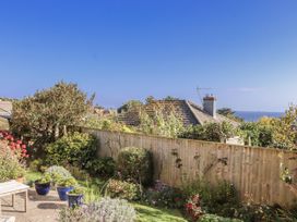 A garden with plants and a fence at Woodbury Teignmouth