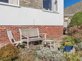 A garden with a bench and table at Woodbury Teignmouth