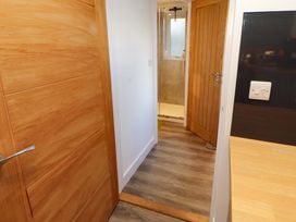 A hallway leading to a bathroom with a shower at Westerlodge Threlkeld near Keswick
