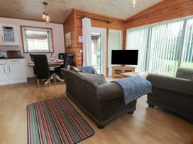 A living room with a sofa and dining table at Woodlands View in Leek