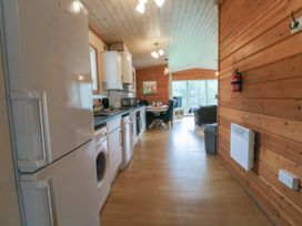 A kitchen with appliances and dining area at Woodlands View in Leek