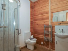A bathroom with a shower, toilet, and sink at Woodlands View in Leek