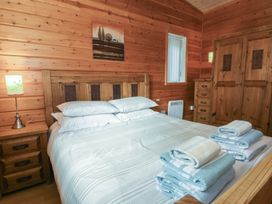 A bedroom with a bed and nightstand at Woodlands View in Leek