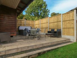 An outdoor seating area with table and chairs at Woodlands View in Leek
