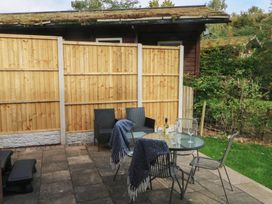 A garden with table and chairs and a fence at Woodlands View in Leek
