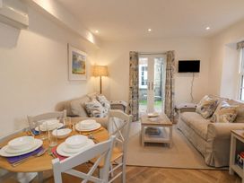 A living room with a sofa and dining table at Quay cottage in Salcombe