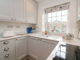 A kitchen with cabinets and a sink at Quay cottage in Salcombe