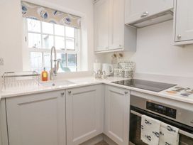 A kitchen with a sink and stove at Quay cottage in Salcombe