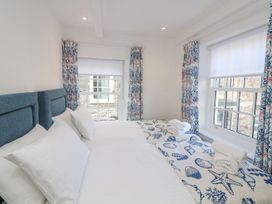 A bedroom with two beds and curtains at Quay cottage Salcombe