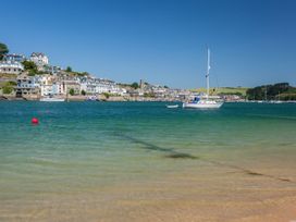A view of boats on water with homes and hills in the background at Quay cottage Salcombe
