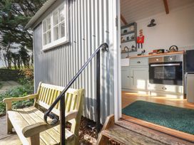 A kitchen with a door and window leading to the outside at Hillbre Shepherd Hut, Padstow