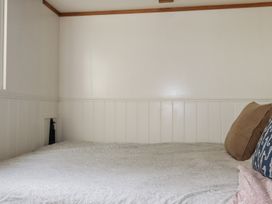 A bedroom with a bed and pillows at Hillbre Shepherd Hut in Padstow