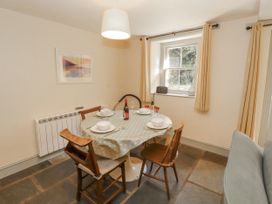 A dining room with a table and chairs at Rock Cottage in Milnthorpe